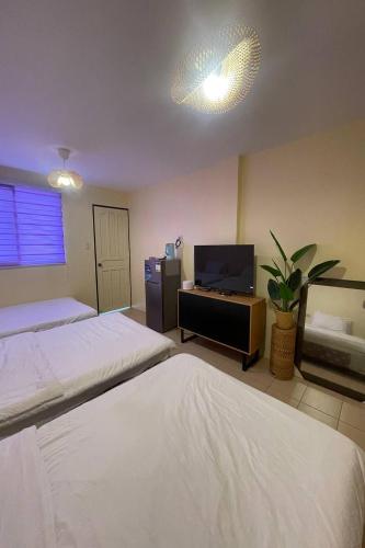 a hotel room with two beds and a tv at Surfside hostel LU Surftown in San Juan