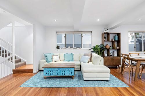 a living room with a couch and a table at Pool side Luxury pet friendly - walk to the beach in Alexandra Headland