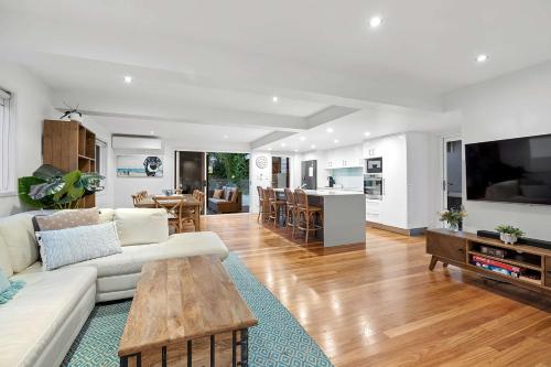 a living room with a couch and a table at Pool side Luxury pet friendly - walk to the beach in Alexandra Headland
