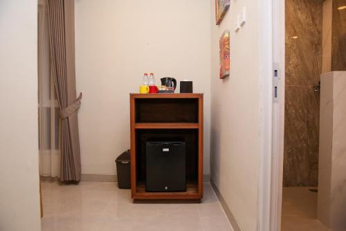 a small wooden stand with a black box on it at Avery Coconut Island Waterpark Beach Resort Carita in Carita