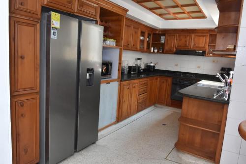 une cuisine avec un réfrigérateur en acier inoxydable et des armoires en bois dans l'établissement spectacular Casa Ashley, à Cali