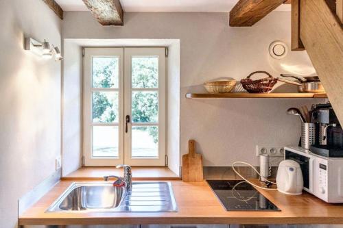 une cuisine avec un évier et une fenêtre dans l'établissement Petite maison charmante à Cons-la-Grandville avec terrasse et jardin, à Cons-la-Grandville