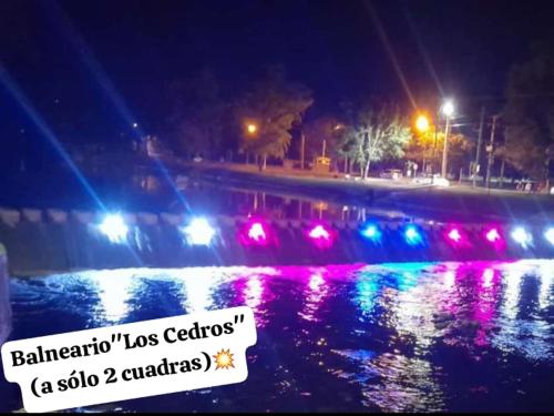 eine nächtliche Aussicht auf einen Fluss mit bunten Lichtern in der Unterkunft CASA - HAUS - Villa Cura Brochero in Villa Cura Brochero