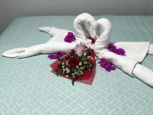 a bouquet of flowers and towels on a table at Apartamentos Equipados DMR #3 in Uvita