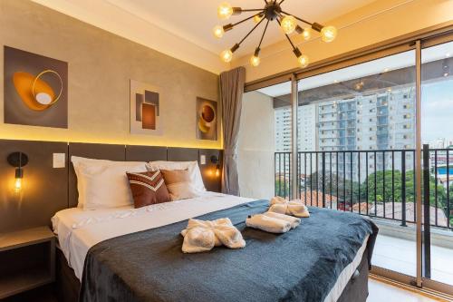 a bedroom with a large bed and a large window at Nik Perdizes in Sao Paulo