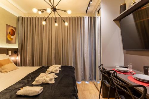 a room with a bed and a table with towels at Nik Perdizes in Sao Paulo