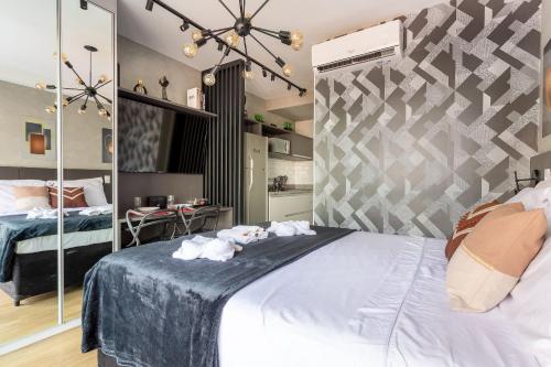 a bedroom with a large bed with towels on it at Nik Perdizes in Sao Paulo