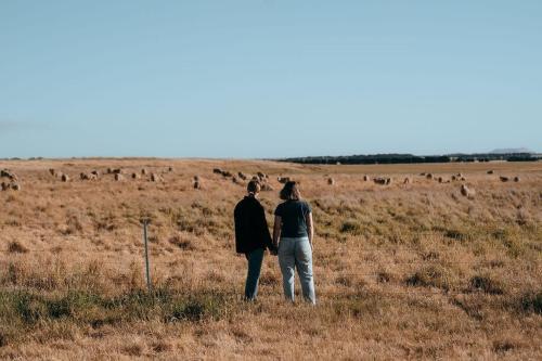 a man and a woman standing in a field at Tiny Lenore in Dunkeld