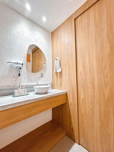 a bathroom with a sink and a mirror at Noronheiro Boutique & House in Fernando de Noronha