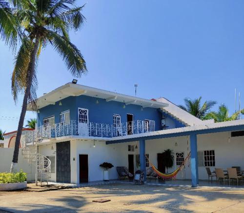 a blue and white house with a palm tree at Casa Punta Perula in Pérula