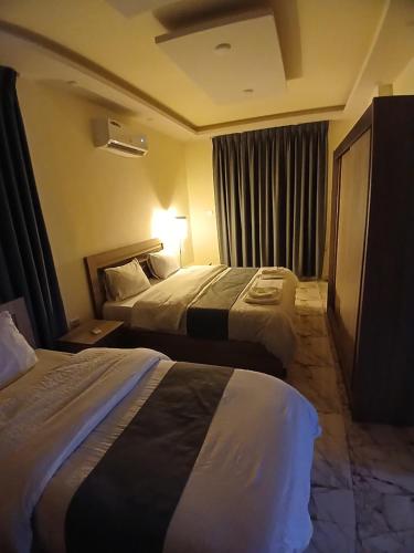 a hotel room with two beds and a window at dream house hotel in Jerash