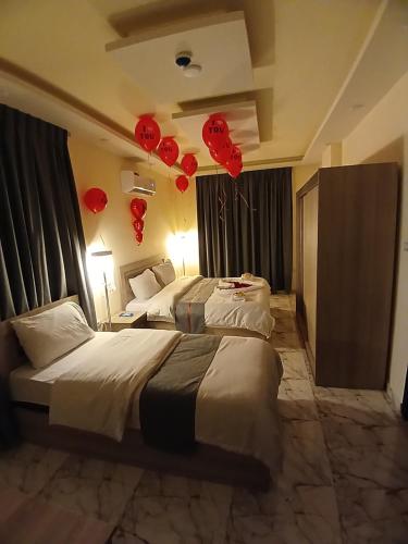 two beds in a hotel room with red balloons at dream house hotel in Jerash
