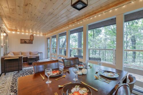 a dining room with a table and chairs and windows at Treetop Hideaway - Summer Escape with HOT TUB in Gatlinburg