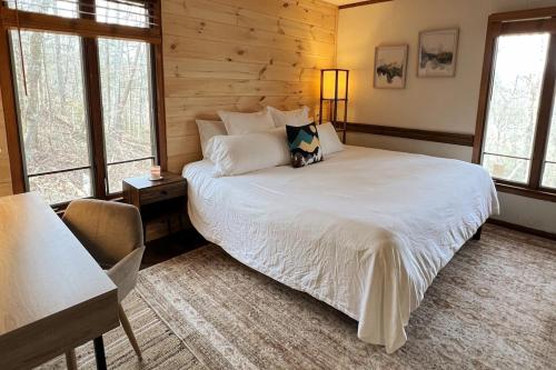 a bedroom with a white bed in a room with windows at Treetop Hideaway - Summer Escape with HOT TUB in Gatlinburg