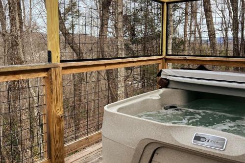 a hot tub in a bird house in front of a window at Treetop Hideaway - Summer Escape with HOT TUB in Gatlinburg