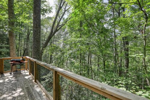 a deck with a view of the woods at Treetop Hideaway - Summer Escape with HOT TUB in Gatlinburg