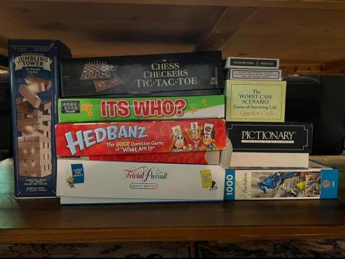 a pile of books sitting on a shelf at Treetop Hideaway - Summer Escape with HOT TUB in Gatlinburg