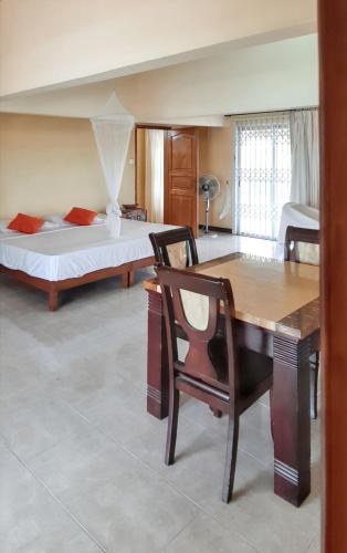 a bedroom with a bed and a desk and a chair at Charming house in Trou aux Biches with mountain view in Trou aux Biches