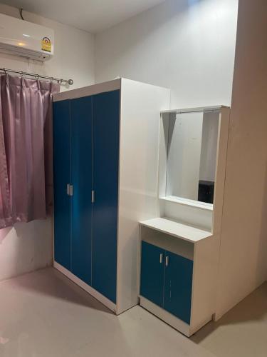 a bathroom with a blue cabinet and a mirror at บ้านสวนรัญจวนสาขาสุราษฎร์ธานี in Ban Huai Chiat