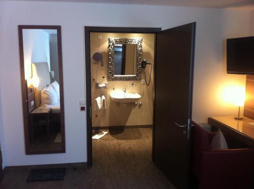 a bathroom with a sink and a mirror at Hotel-Restaurant Pfälzer Hof in Edenkoben