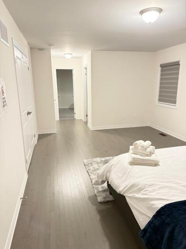a white room with a bed and a hallway at 4-Bdrm Comfort with Fireplace mins from Downtown in Port Colborne