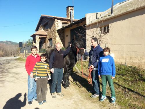 un grupo de personas de pie junto a un caballo en Madre Terra, en La Puebla de la Sierra