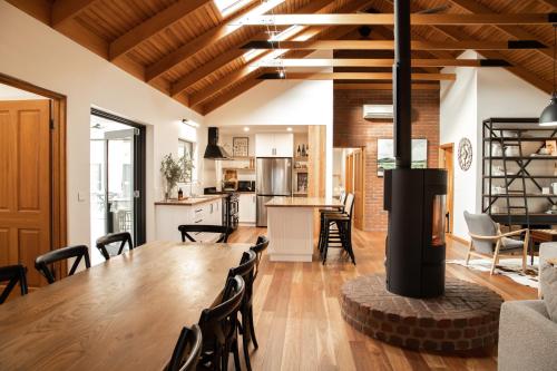 a kitchen and dining room with a wooden table and chairs at Athlete's Retreat - 21A Service Street in Porepunkah