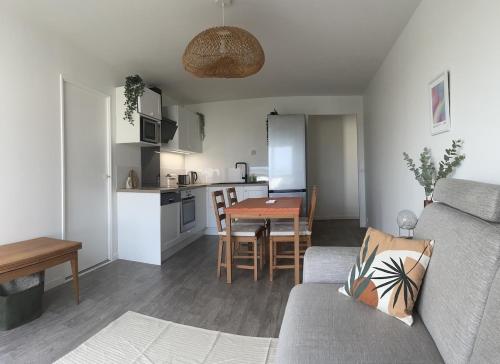 un salon et une cuisine avec un canapé et une table dans l'établissement 5 min Versailles & Golf National, à Guyancourt