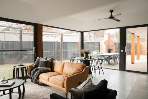 a living room with a couch and tables at Athlete's Retreat - 21A Service Street in Porepunkah