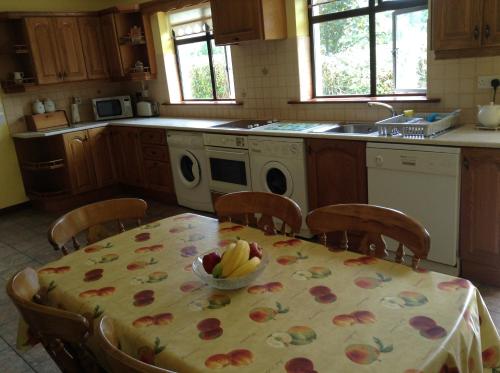 una cocina con una mesa con un bol de fruta. en Riverlodge Self Catering en Kenmare