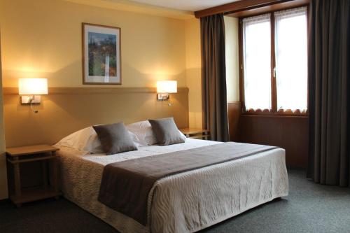 a bedroom with a bed with two pillows on it at Auberge des Trois Châteaux in Eguisheim