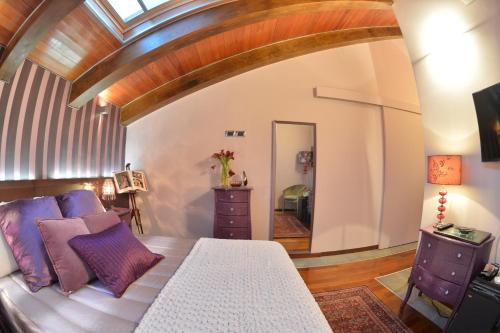 a bedroom with a bed with purple pillows and a mirror at Hotel Dei Pittori in Turin