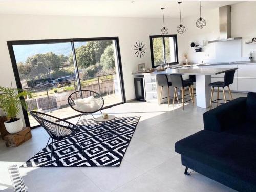 un salon avec un canapé et une table et une cuisine dans l'établissement MaisonDrs, à Porto-Vecchio
