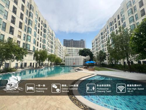 a large swimming pool in front of some buildings at Sunlit Nest Sukhumvit in Ban Khlong Samrong