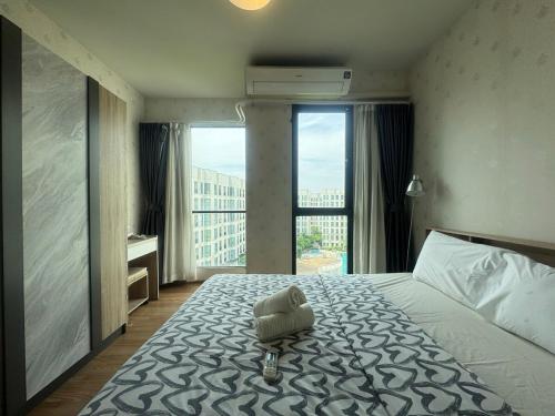 a hotel room with a bed with a towel on it at Sunlit Nest Sukhumvit in Ban Khlong Samrong