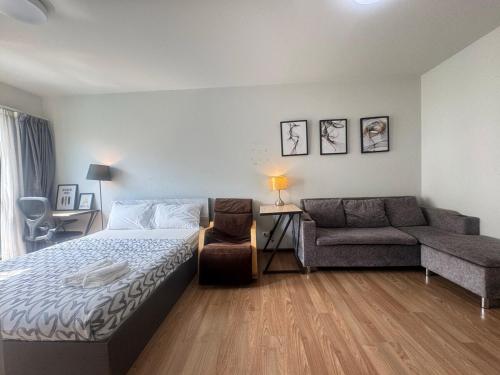 a bedroom with a bed and a couch at Sunlit Nest Sukhumvit in Ban Khlong Samrong