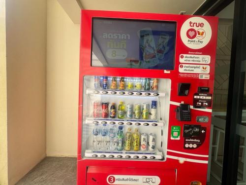 a red vending machine with bottles of soda at Sunlit Nest Sukhumvit in Ban Khlong Samrong