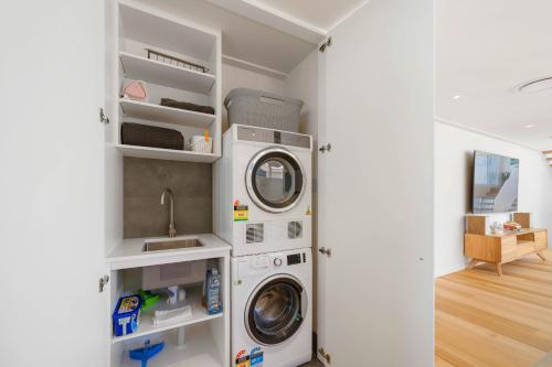 a laundry room with a washer and dryer at Noahs Beach House - at Flynns in Port Macquarie