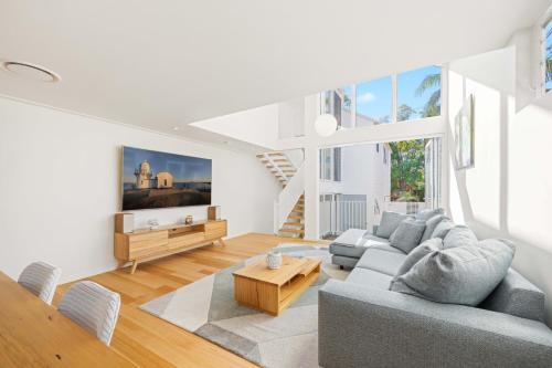 a living room with a couch and a table at Noahs Beach House - at Flynns in Port Macquarie