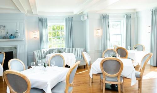 a dining room with white tables and chairs at The White House Inn in Wilmington