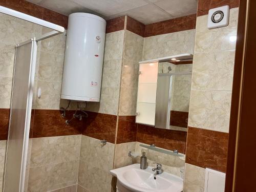 a bathroom with a sink and a mirror at Sea Coast Apartment - 17 pools included in Sveti Vlas