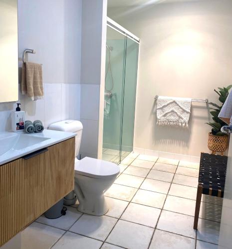 a bathroom with a toilet and a glass shower at Anchor Ocean Grove - Fireplace, Wineries, Cafes, Bars, Surf in Ocean Grove