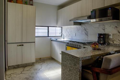 a kitchen with white cabinets and a counter top at Casa Moderna con Alberca en Morelos in Xochitepec