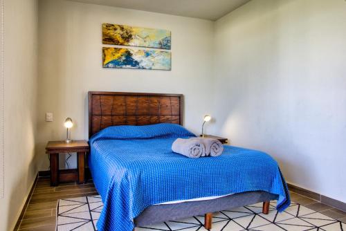 a bedroom with a blue bed with two towels on it at Casa Moderna con Alberca en Morelos in Xochitepec