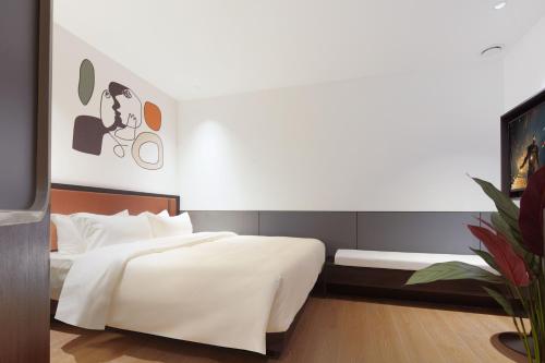 a bedroom with a large white bed and a tv at Mcsrh Hotel-Chengdu Chunxi Road in Chengdu