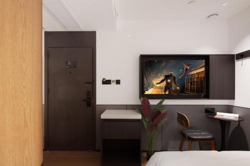 a room with a tv on a wall with a bed at Mcsrh Hotel-Chengdu Chunxi Road in Chengdu