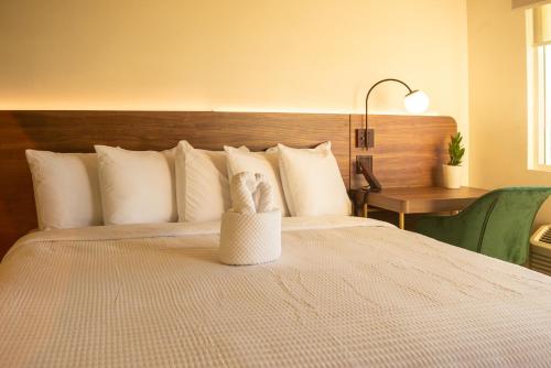 a bedroom with a large bed with white pillows at The Alice Hotel in Tucson