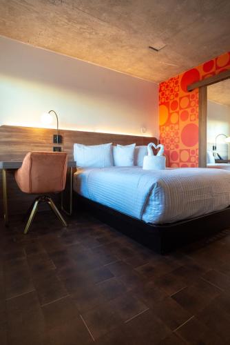 a hotel room with a large bed and a desk at The Alice Hotel in Tucson