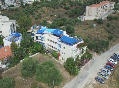 an aerial view of a building with a blue roof at Heliotopos Apartments in Tolo
