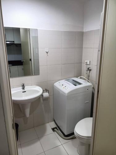 a white bathroom with a sink and a toilet and a sink at Roiden Sea Residences in Manila